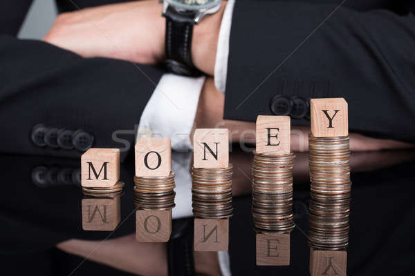 Businessman With Money Blocks On Stacked Coins Stock photo © AndreyPopov