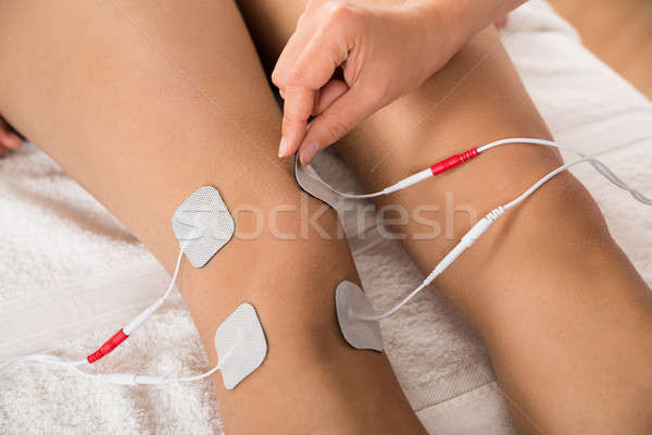 Therapist Placing Electrodes On Woman's Knee Stock photo © AndreyPopov