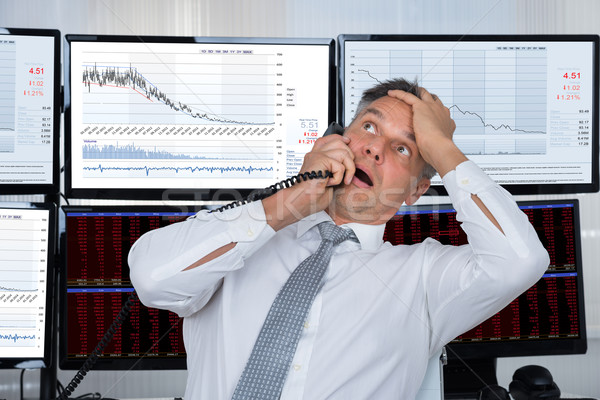 Sad Stock Trader With Hand On Head Using Telephone Stock photo © AndreyPopov