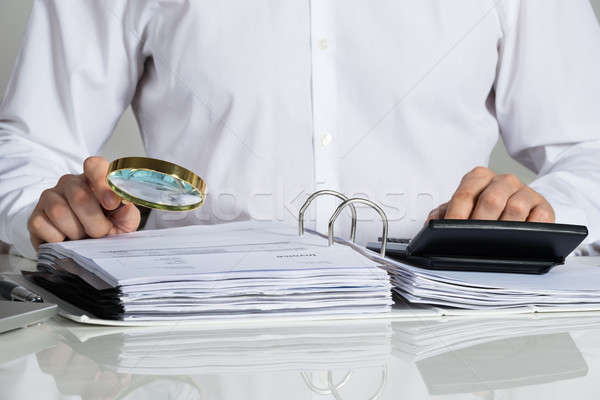 Zakenman onderzoeken factuur vergrootglas bureau Stockfoto © AndreyPopov