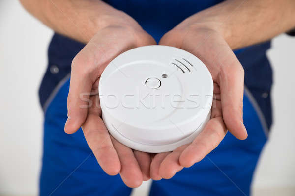 Stock photo: Close-up Of Electrician Holding Smoke Detector