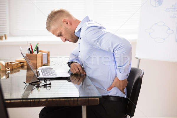 Biznesmen posiedzenia biurko laptop biuro Zdjęcia stock © AndreyPopov