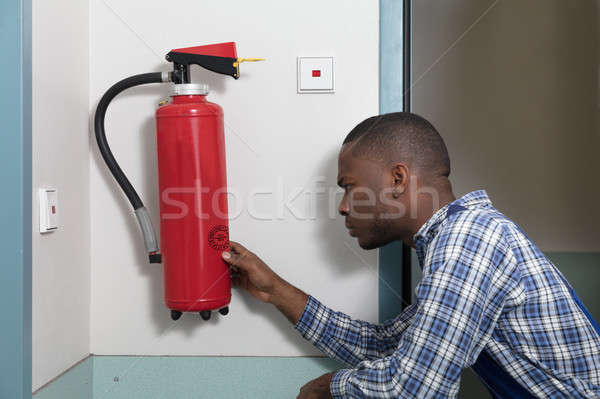 Male Professional Checking A Fire Extinguisher Stock photo © AndreyPopov