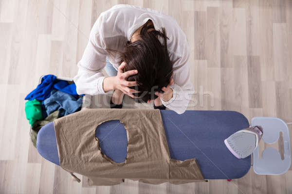 Woman Standing By Ironing Board With Burned Cloth Stock photo © AndreyPopov