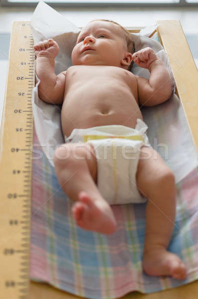 Cute baby lying in height meter Stock photo © anmalkov