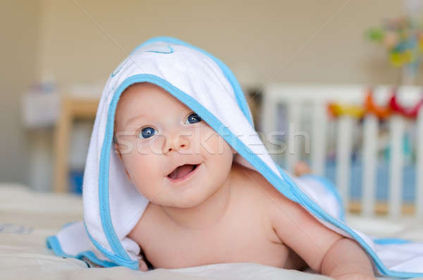 Stock photo: Smiling baby in a hooded towel after bath