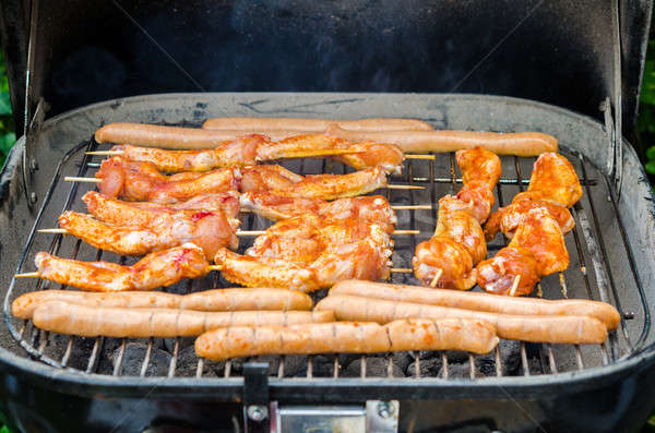 Kolbászok tyúk szárnyak dohányzás grill barbeque Stock fotó © anmalkov