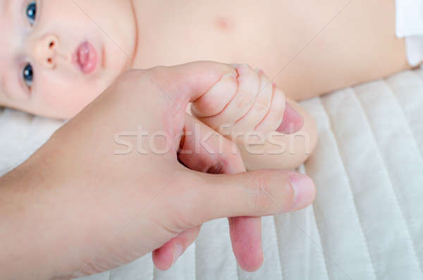 Cute newborn baby boy holding young father's finger Stock photo © anmalkov