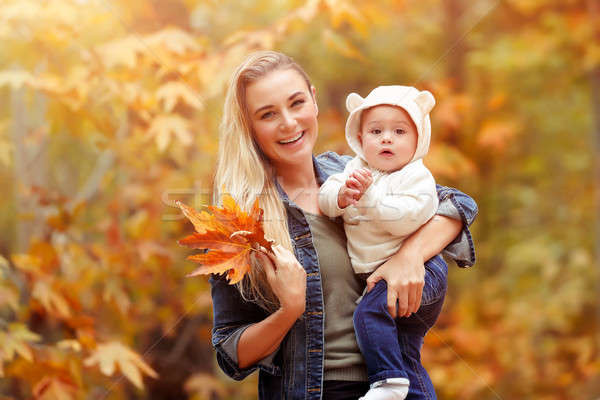 Stock photo: Happy mother with baby in autumn park