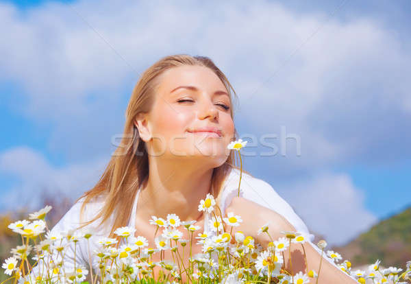 Stock photo: Beautiful woman enjoying daisy field and blue sky