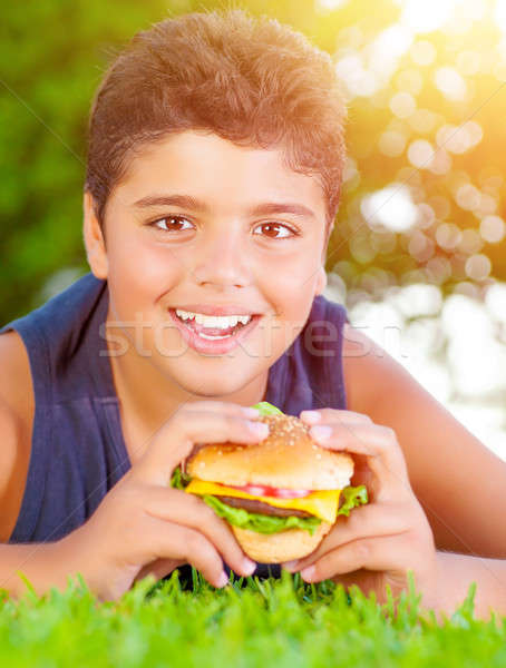 Arabic boy eating burger outdoors Stock photo © Anna_Om