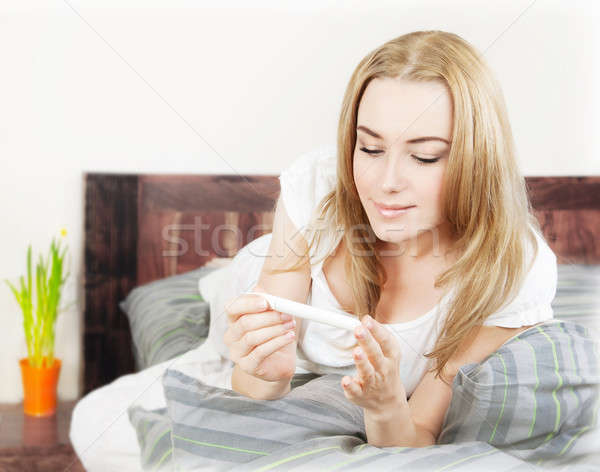 Stock photo: Happy woman holding pregnancy test