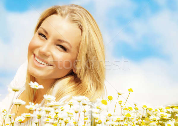 Stock photo: Beautiful woman enjoying daisy field and blue sky