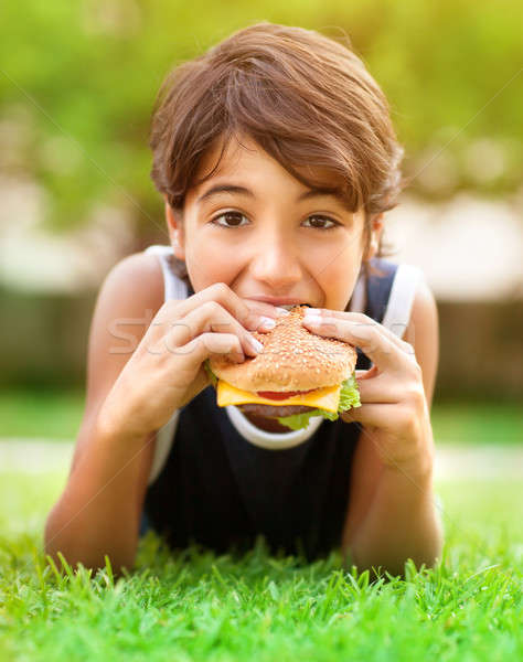 Teen boy eating burger outdoors Stock photo © Anna_Om