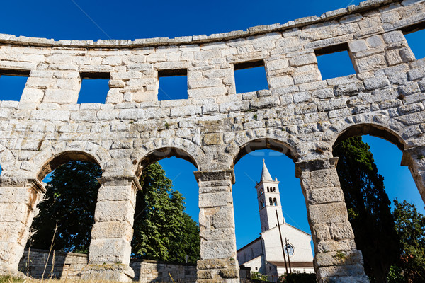 Stock photo: White Church Framed in the Arch of Ancient Roman Amphitheater in