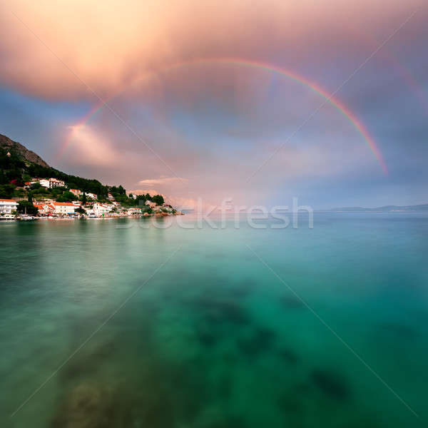 Rainbow over Rocky Beach and Small Village after the Rain, Dalma Stock photo © anshar