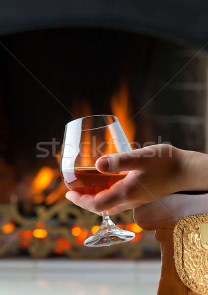 Resting at the burning fireplace fire with a glass of cognac Stock photo © Antartis