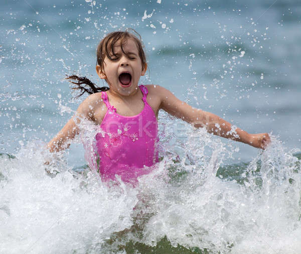 Little girl laughing and crying in the spray of waves Stock photo © Antartis