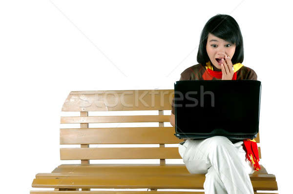 Młoda kobieta zdziwiony patrząc laptop odizolowany biały Zdjęcia stock © antonihalim