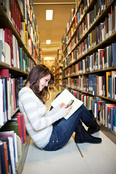 Félvér diák portré főiskolai hallgató sms chat könyvtár Stock fotó © aremafoto