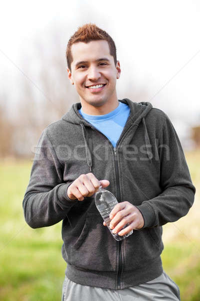 Félvér férfi tart vizes flakon lövés szabadtér Stock fotó © aremafoto
