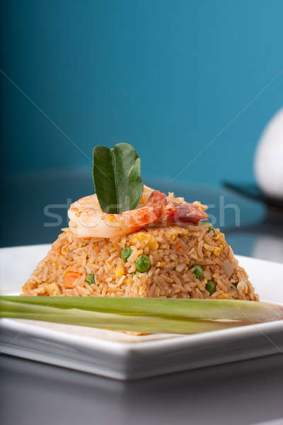 rice presented on a square white plate in the shape of a pyramid