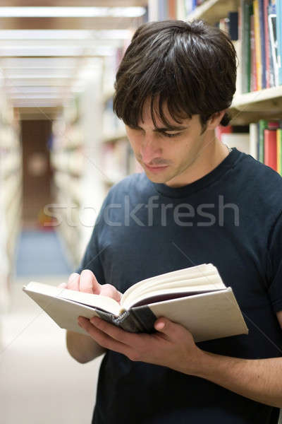 Student biblioteki młody człowiek książki stałego półki Zdjęcia stock © ArenaCreative
