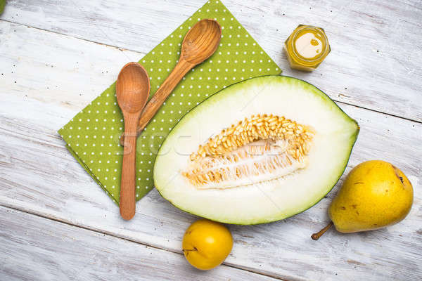 Half cut melon with honey and pears in rustic style Stock photo © Arsgera