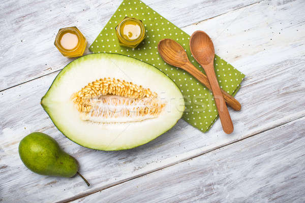 Cut melon green pear and honey on rustic board Stock photo © Arsgera