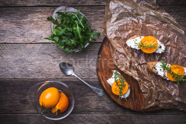 Bruschetta with cheese, tomatoes and salad rocket in rustic styl Stock photo © Arsgera