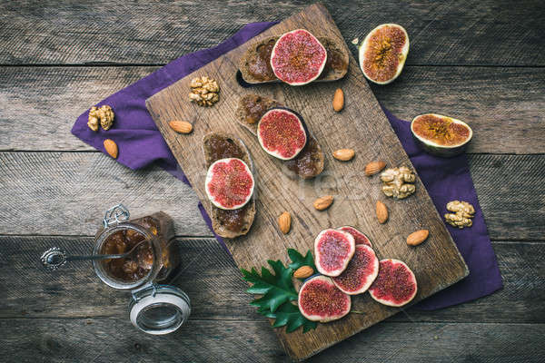 Stock photo: Sliced figs, nuts and bread with jam on choppingboard in rustic 