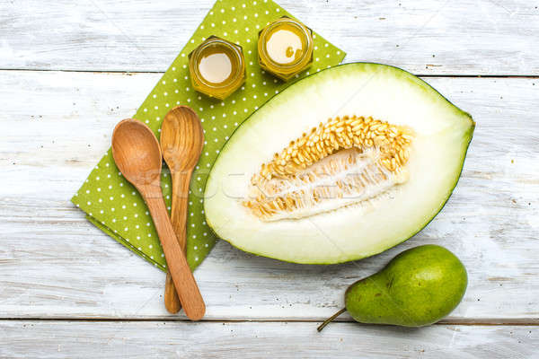 Cut melon green pear and honey on white board Stock photo © Arsgera
