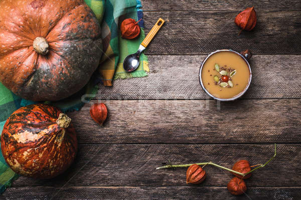 Pumpkins and soup with seeds and ground cherry on wooden table Stock photo © Arsgera