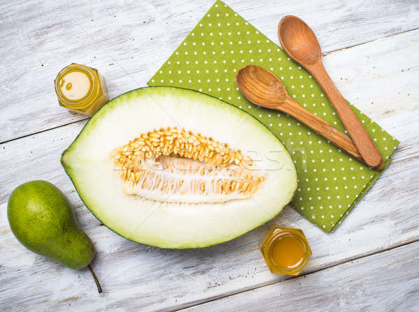Ripe melon with honey and pear on white wood Stock photo © Arsgera