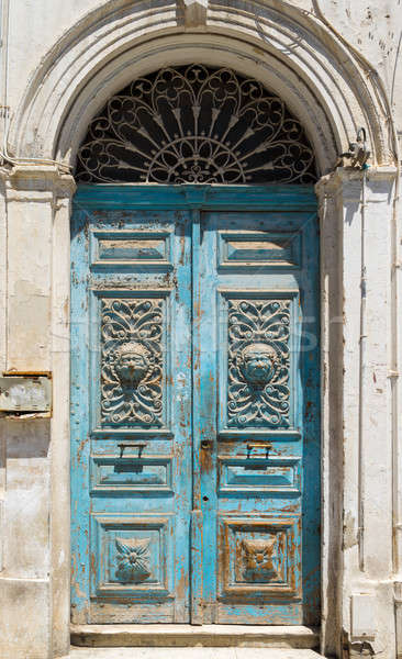 Blue aged Tunisian wooden door with arch and ornament Stock photo © Arsgera