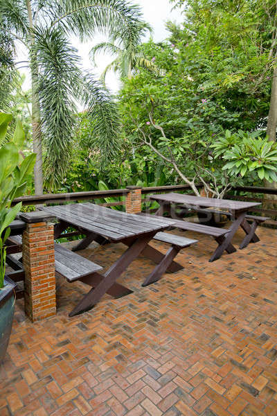 Wooden chairs and table set at balcony in a green plant garden. Stock photo © art9858