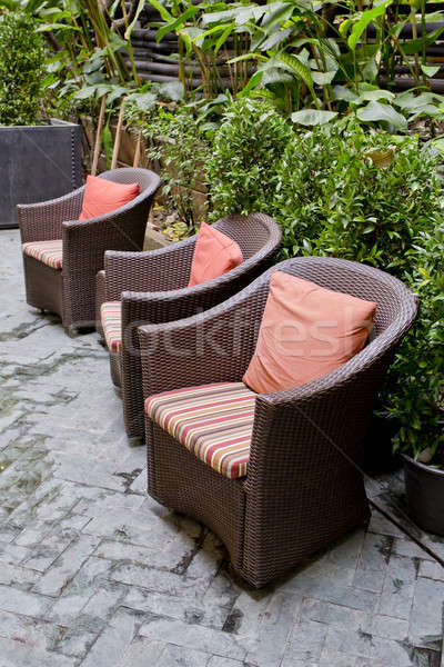 Rattan chair and rattan coffee table with green trees at outdoor Stock photo © art9858