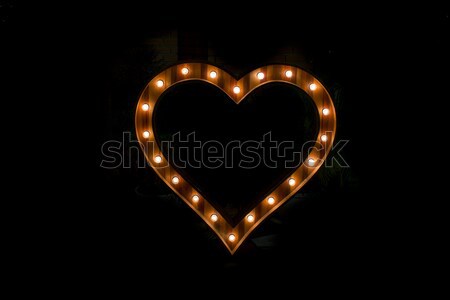 Heart sign with light bulb isolate on black background Stock photo © art9858