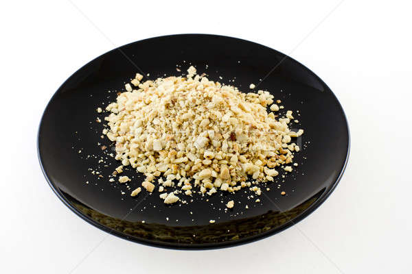 Crushing Peanuts for thai noodle on black plate isolate white ba Stock photo © art9858
