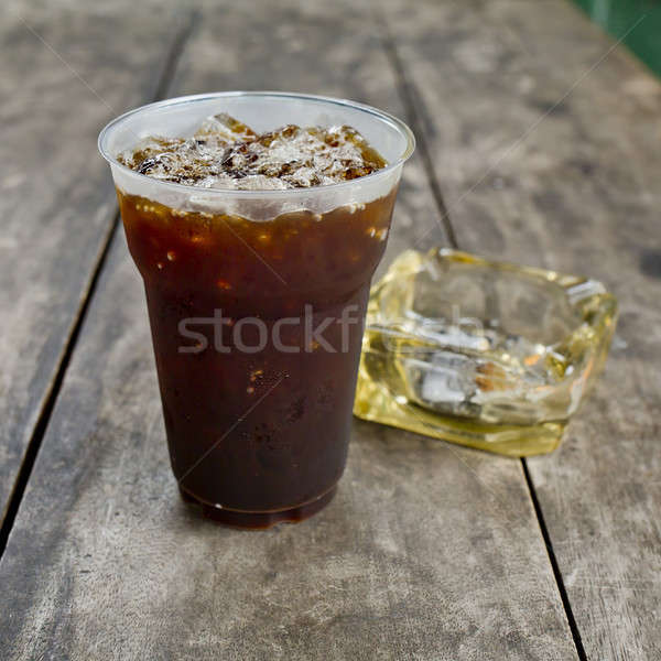Delicious ice coffee americano  with cigarette on the old wooden Stock photo © art9858