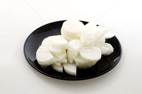 Daikon radishes on black dish isolated on white background Stock photo © art9858