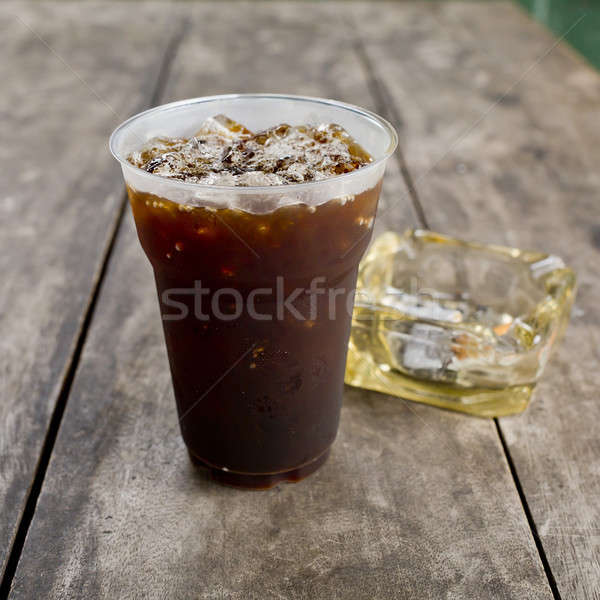 Delicious ice coffee americano  with cigarette on the old wooden Stock photo © art9858