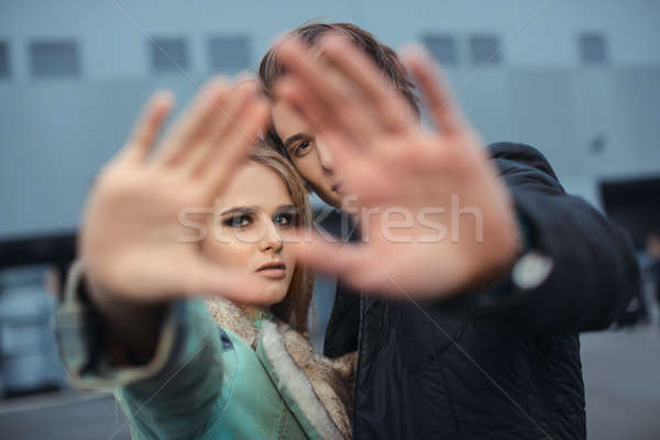 Couple hiding faces from paparazzi outdoors Stock photo © artfotodima