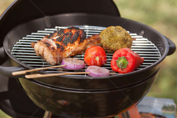 Fresh meat and vegetables on outdoor grill Stock photo © artfotodima