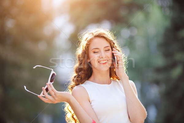 Woman walking on the street and talking by phone Stock photo © artfotodima