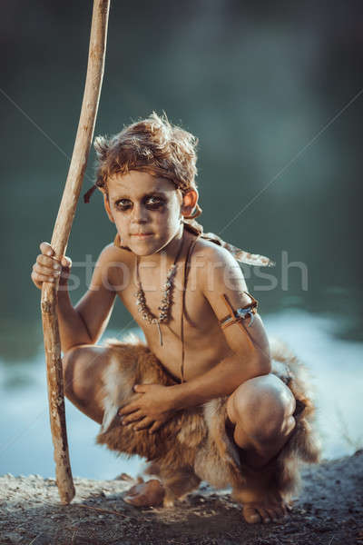 Cute caveman, manly boy with staff hunting outdoors. Ancient warrior Stock photo © artfotodima