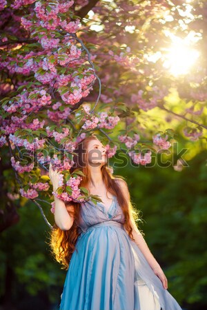 Belo mulher jovem em pé florescimento árvore jardim Foto stock © artfotodima