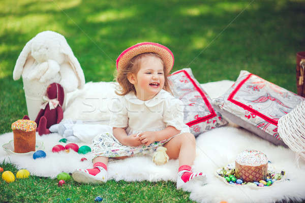 Happy child sits on a meadow around easter decoration Stock photo © artfotodima