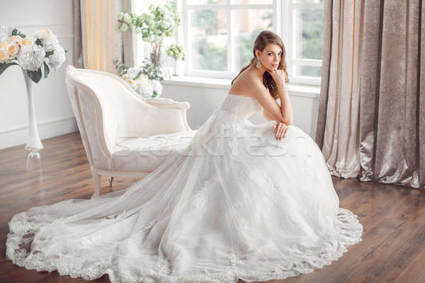 Bride in beautiful dress sitting resting on sofa indoors Stock photo © artfotodima