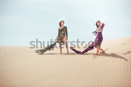 Travel concept. Two gordeous women sisters traveling in desert. Stock photo © artfotodima